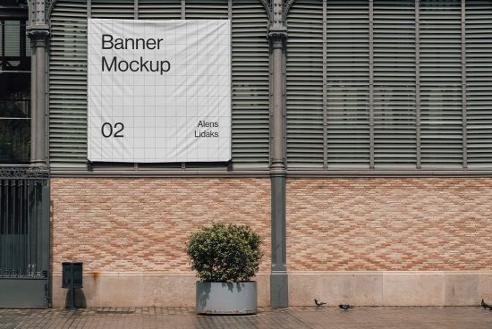 Outdoor banner mockup on a brick wall by a sidewalk with a plant and pigeons, ideal for urban advertising design presentation.