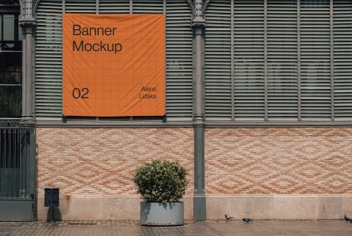 Alt: Urban outdoor banner mockup hanging on a classic building facade, ideal for realistic advertising presentations, graphic design asset.