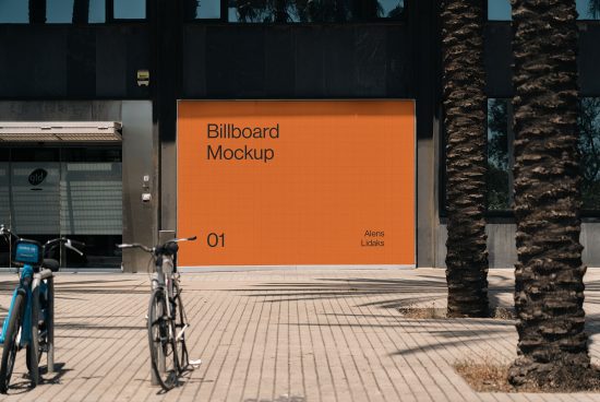 Outdoor billboard mockup on a building's facade with editable surface for graphic design presentation, flanked by palm trees and bicycles.
