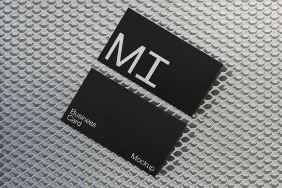 Business card mockup with elegant black design laying on textured surface, ideal for presenting professional branding graphics.
