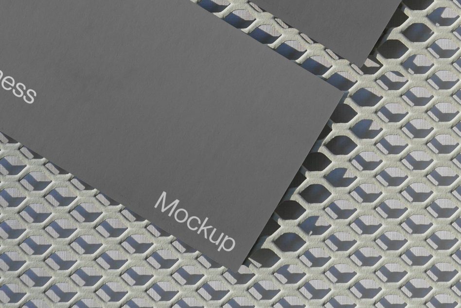 Business card mockup on textured metal grid, elegant presentation for design branding, high-quality visual for portfolio display.