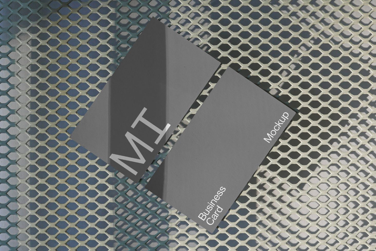 Stylish business card mockup with modern design, shadow overlay on a metallic grid background, ideal for brand presentation and portfolio displays.