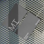 Stylish business card mockup with modern design, shadow overlay on a metallic grid background, ideal for brand presentation and portfolio displays.