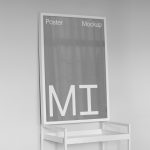 Minimalist poster mockup in monochrome standing on a sleek frame for graphic designers to showcase their work in a modern setting.