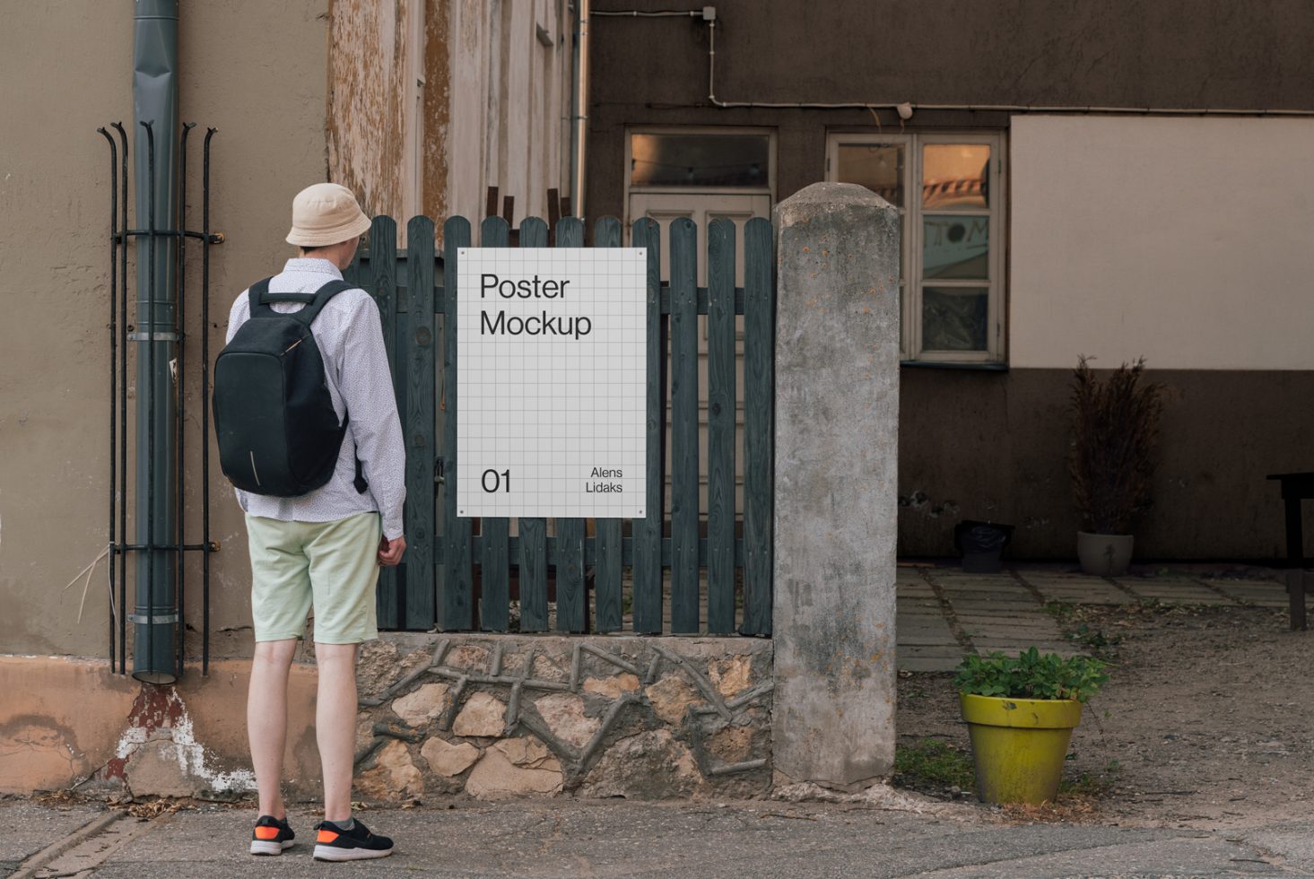 Person viewing urban poster mockup on a fence for outdoor advertising design presentation, realistic street environment.