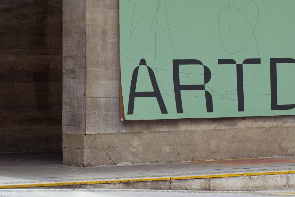 Sage green horizontal signage with bold black typography on concrete wall