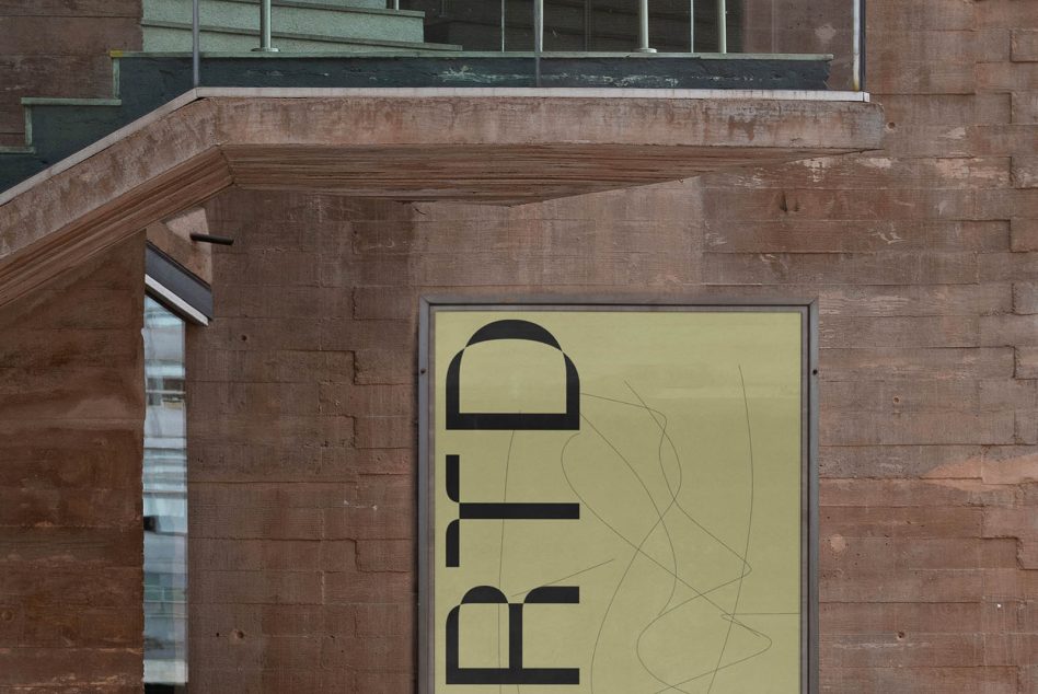 Pale yellow wall sign showing stacked sans serif letters in black