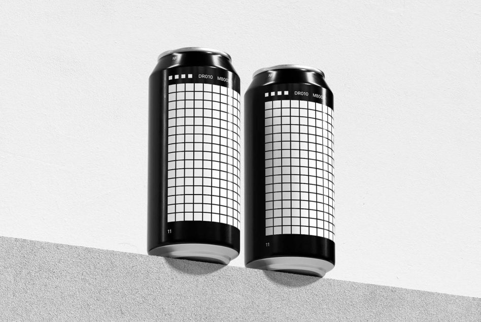 Two black cans with grid pattern label design on neutral split background