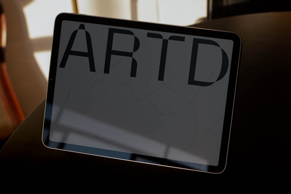 iPad displaying large letter forms with wireframe graphics underneath