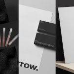 Professional stationery mockup with business cards, folder, and textured paper on a modern black and white background for design presentations.
