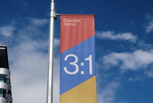 Vertical streetlight banner mockup with a 3:1 ratio, red and blue design against a clear sky. Ideal for outdoor advertising design presentations.