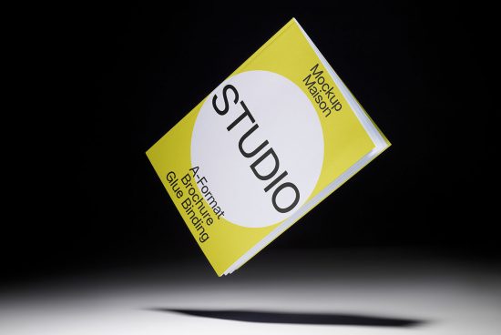 Floating A4 brochure mockup in yellow with glue binding, spotlight effect, contrast black background, ideal for graphic design presentations.