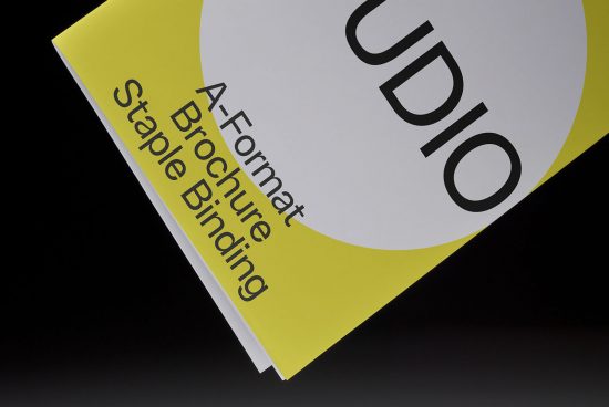 Print design mockup of a yellow A-format brochure with staple binding on a dark background for graphic designers.