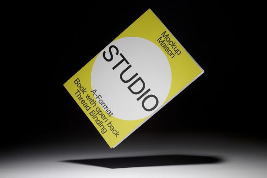 Mockup book design with yellow cover and modern studio branding floating against a black background, showcasing graphics and templates.
