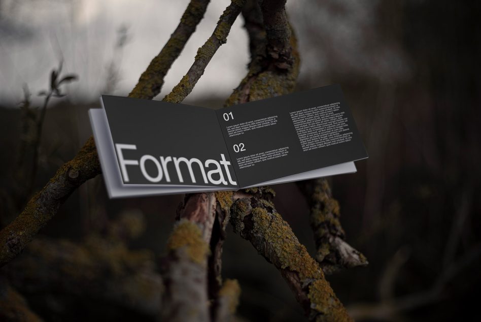 Dark brochure mockup with Format title in white on black pages resting on lichen branches