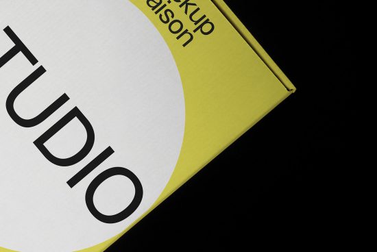 Creative studio branding mockup with bold typography on a circle label over a vibrant yellow package, showcasing modern design.