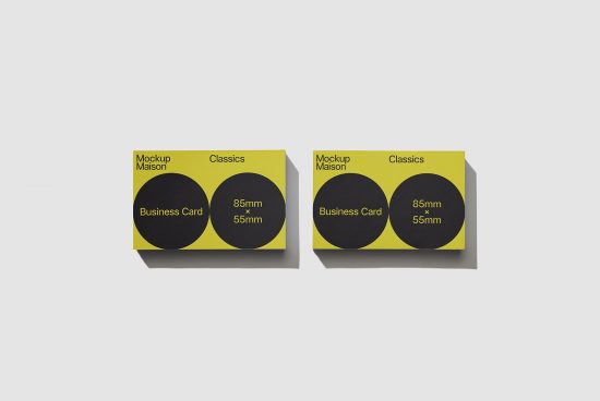 Two business card mockups with a black and yellow design, showing front and back views, isolated on a white background for graphic designers.