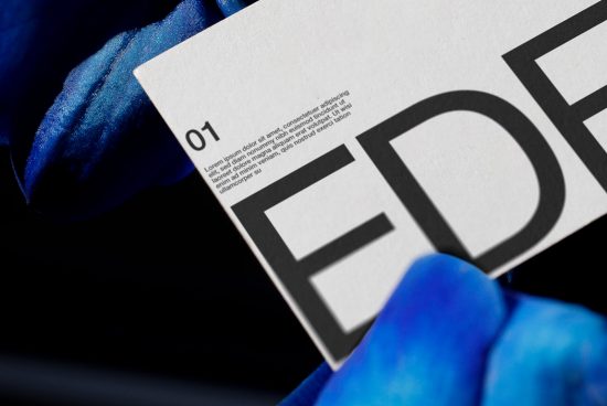 Close-up view of bold typography on paper with blue satin fabric, ideal for mockups and graphic design presentations.
