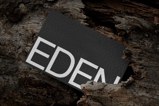 Elegant business card mockup with textured design nestled in natural wood setting, ideal for presentation and branding.