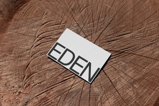 Business card mockup with bold font on textured wooden surface for graphic design presentation and portfolio display.