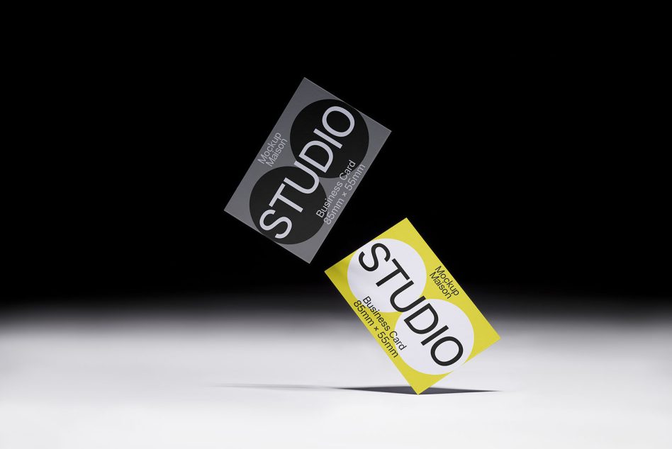Gray business card rotated upright next to bright yellow business card lying flat