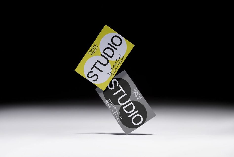 Yellow business card flipped diagonally stacked on gray card, Studio text visible