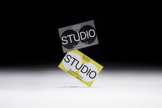 Business card mockup with black and yellow design elements floating on a dark to light gradient background for graphic designers.