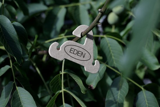 Laser-cut wood puzzle piece with custom branding "EDEN" hanging on a tree, showcasing product design and engraving detail for mockups.