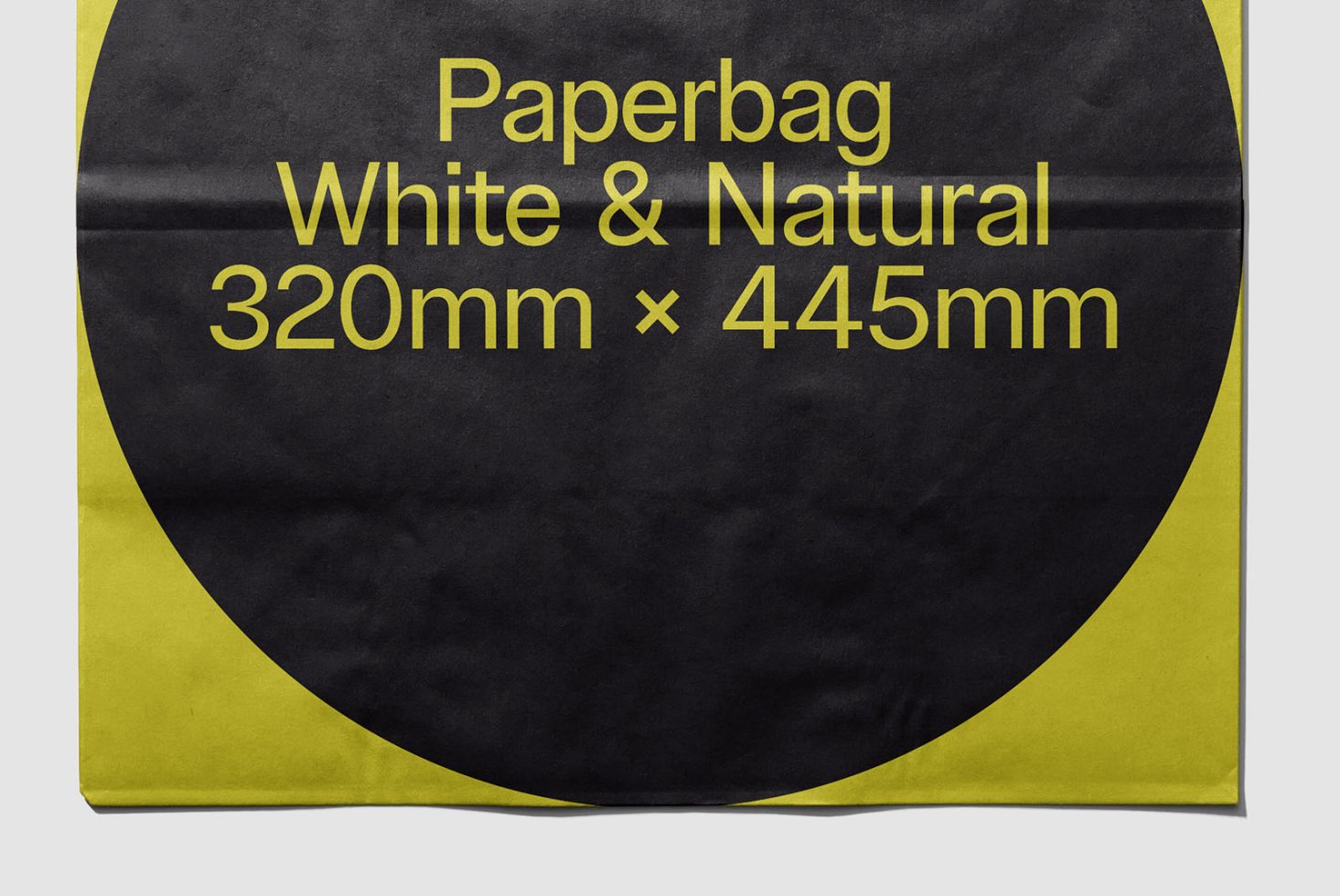 Flat lay of a paper bag mockup with black and yellow design, dimensions 320mm x 445mm for packaging presentations.