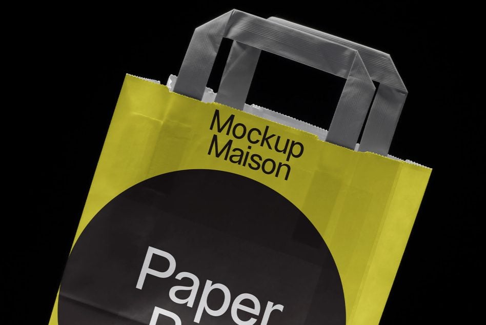 Shopping bag angled view, bright yellow with black circle, large handles visible