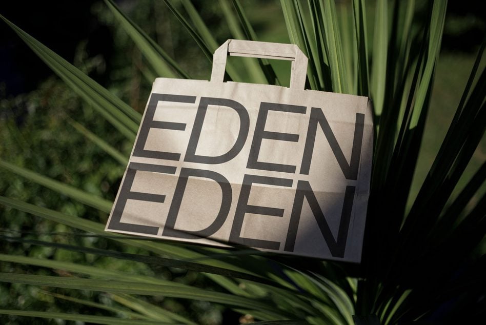 Cream tote with stacked EDEN typography in black, nestled in green foliage