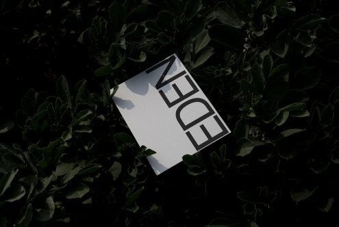 White card with bold black typography mockup lying on green foliage background, showcasing elegant font design, suitable for branding presentations.