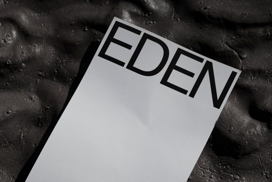 Magazine mockup with text 'EDEN' on a textured black background, conveying a sleek design template for presentations.