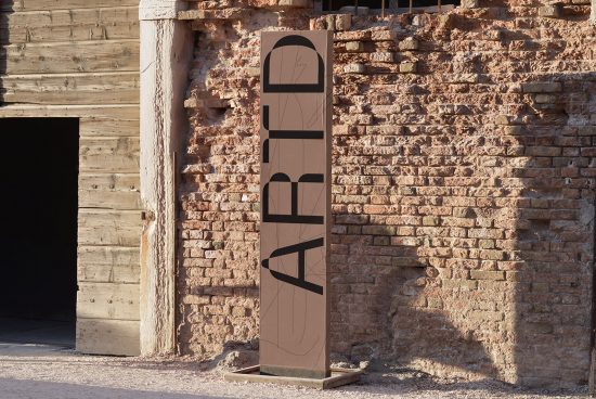 Modern font design displayed on tall banner stand against rustic brick wall setting, showcasing innovative typography for graphic designers.
