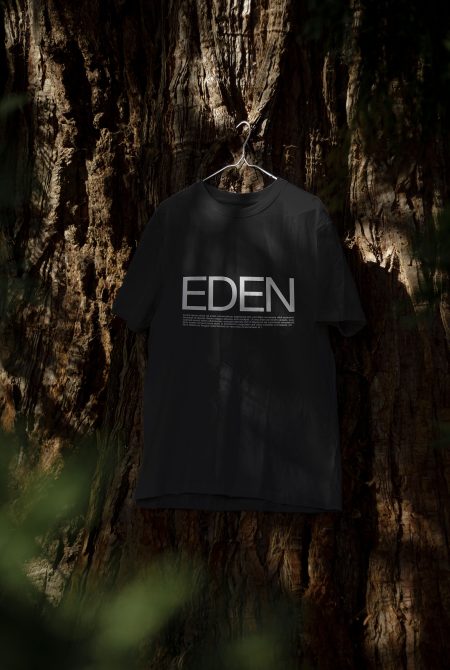 T-shirt mockup with nature theme hanging in a forest setting, showcasing Eden text design, ideal for graphic apparel presentations.