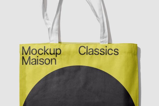 Yellow tote bag mockup with black circle design and text overlay, realistic shadow, high-resolution, perfect for branding presentations.