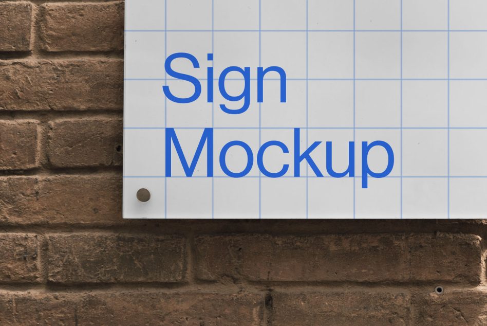 Wall-mounted sign mockup on a brick wall with grid lines for easy design placement, ideal for presenting logos and branding for designers.