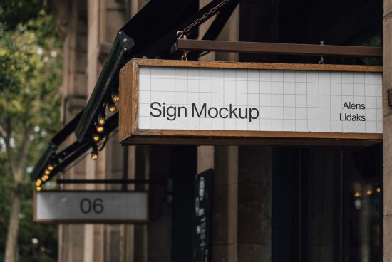 Realistic outdoor sign mockup hanging on a shopfront with customizable design space and warm string lights in a city setting for designers.