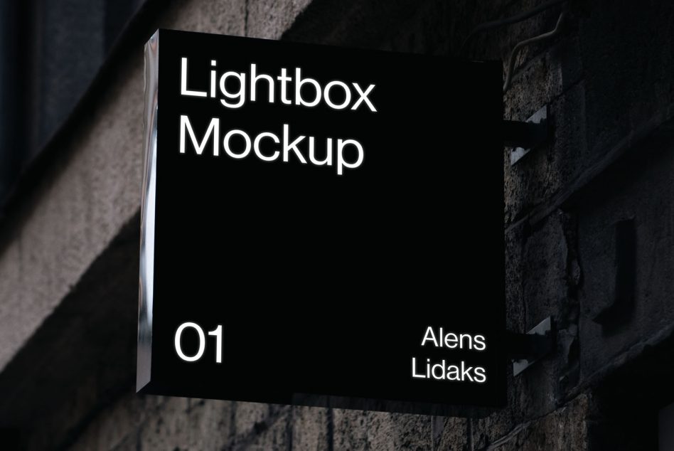 Glowing lightbox sign mounted on dark brick building facade at night