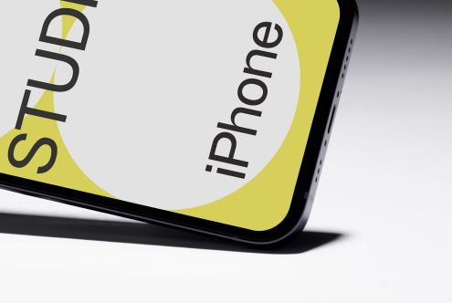 Smartphone mockup on white surface with partial view showing curved screen edge for showcasing mobile designs and user interfaces.