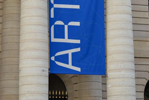 Blue banner graphic design with abstract white typography and lines against columned building, ideal for mockup and template inspiration.