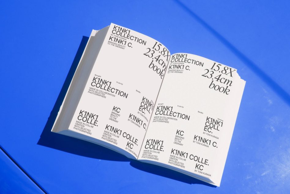 Opened book on blue surface casting shadow with Kinki Collection interior pages visible