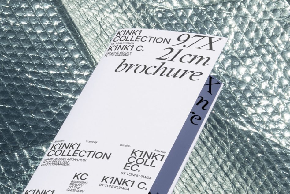 Tall brochure standing on shiny crinkled material with purple spine visible