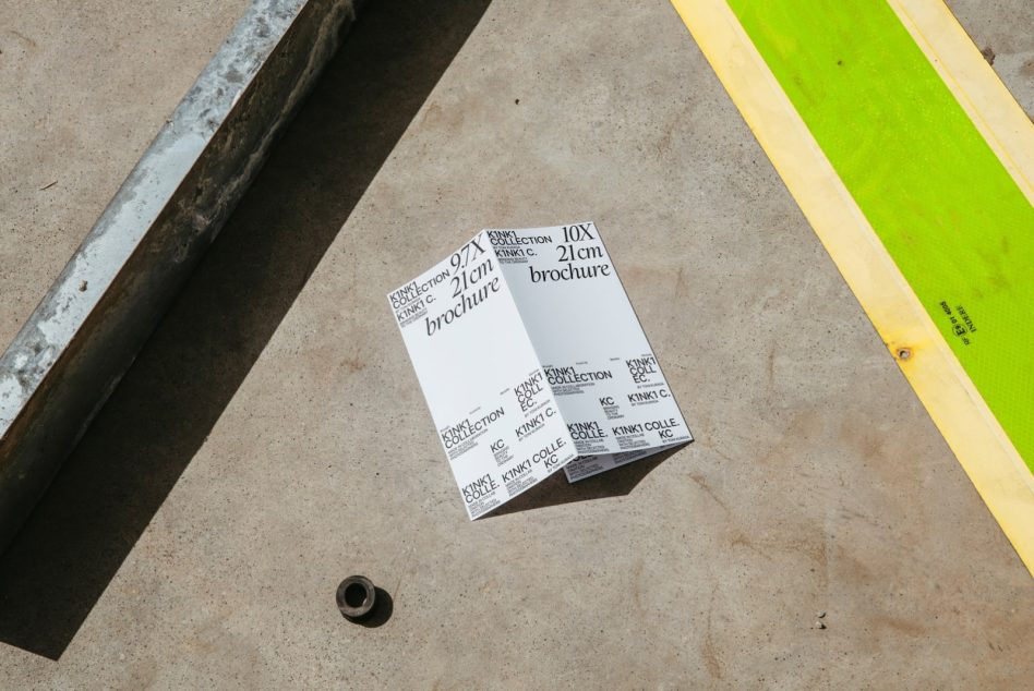Folded A4 brochure mockup on concrete with colored tape stripes