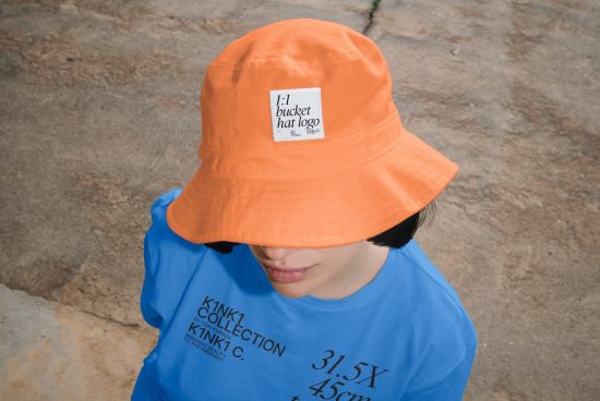 Person wearing vibrant orange bucket hat with logo mockup and blue shirt, ideal for designer mockups, apparel branding, and fashion presentations.