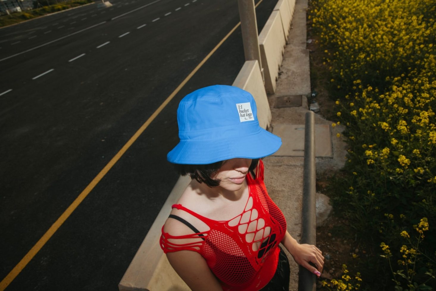 Woman in trendy blue bucket hat and red mesh top outdoors, mockup for hat design, perfect for urban fashion templates.