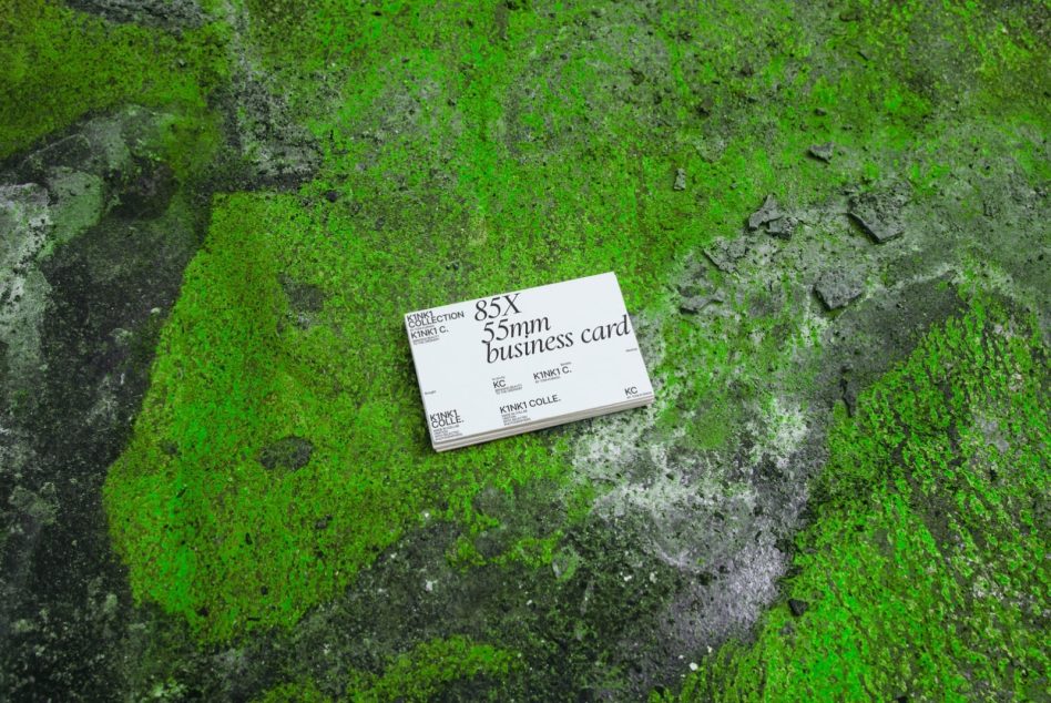 Business card mockup on moss green stone surface with concrete patches
