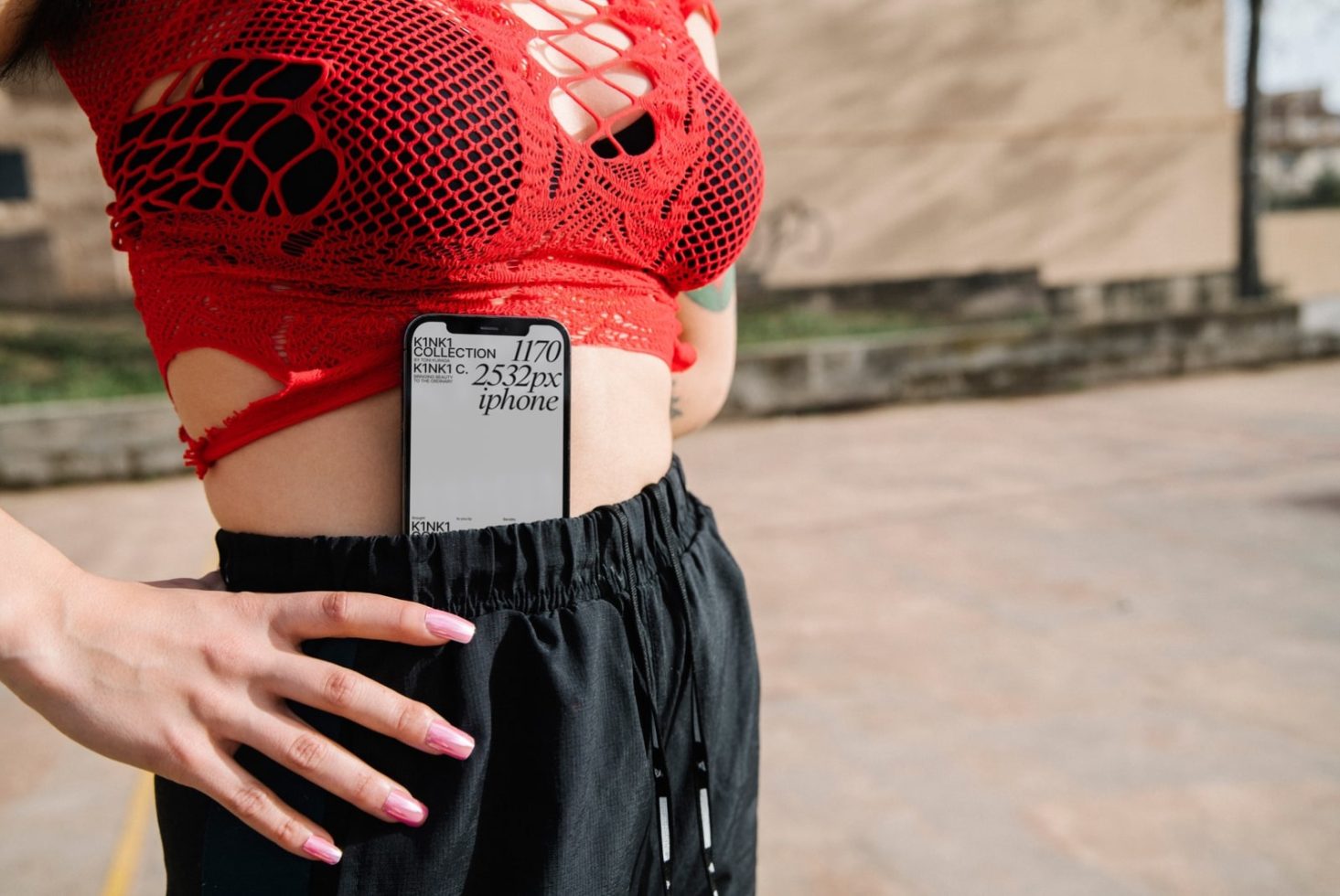 Woman in red mesh top and black pants with smartphone in pocket, urban style, modern fashion mockup.