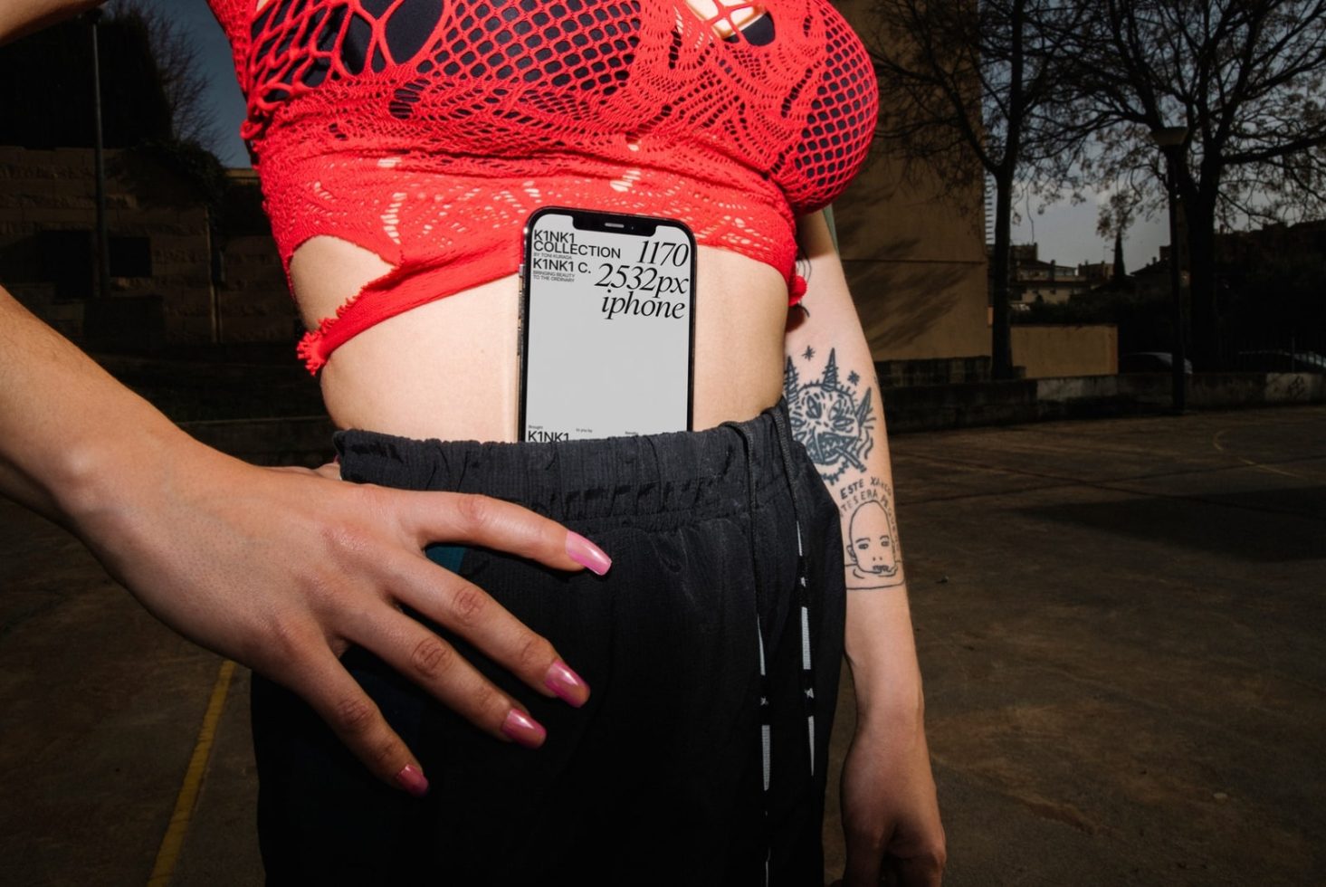 Person with visible tattoo holding a phone in pocket showing screen mockup for design presentation. Ideal for graphics or templates category.