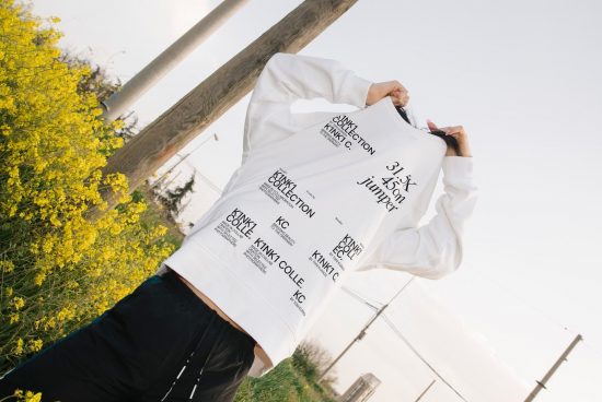 Person in white hoodie with text design standing in field, fashion apparel mockup for designers, trendy clothing template.